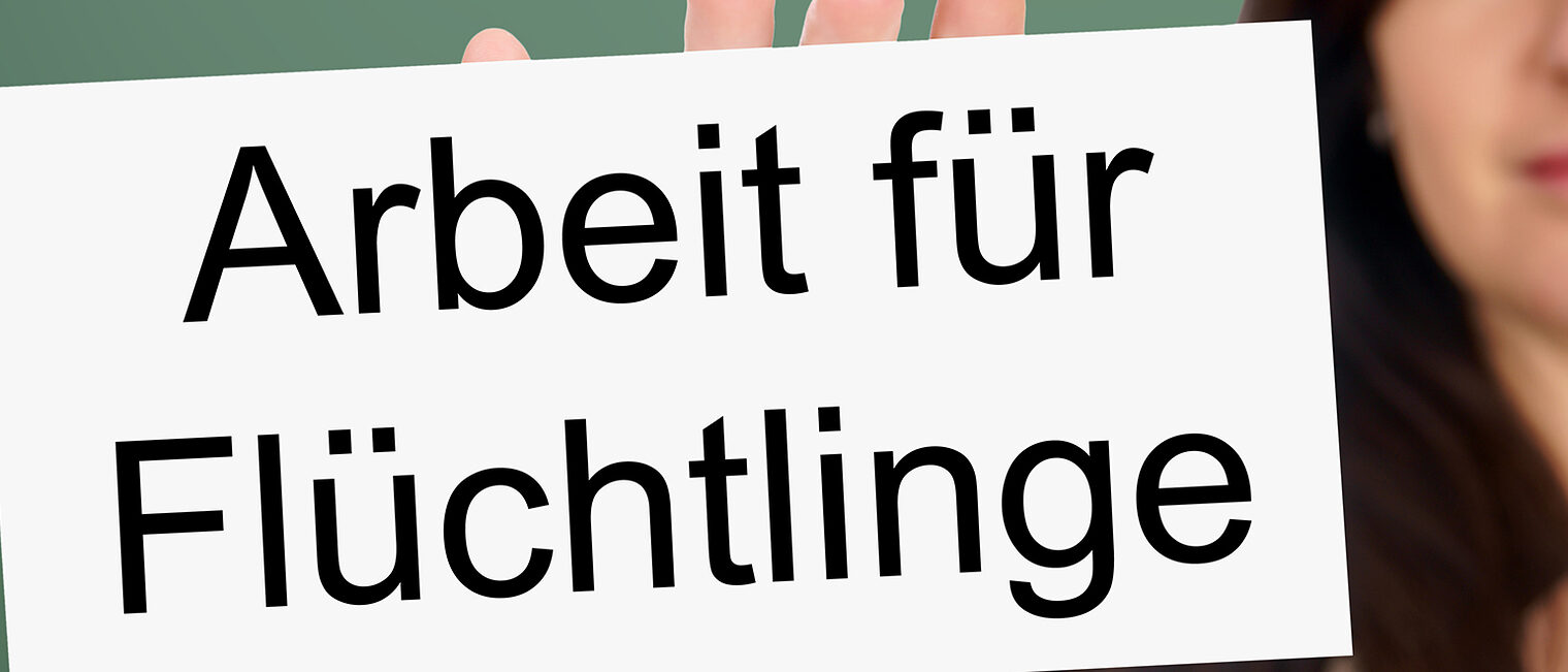 Woman and Sign with the german words Working for Refugees Schlagwort(e): Emergency Services, Women, Escape, Social Services, Immigrant, Refugee, Working, Complexity, Exclusion, Harassment, Social Issues, War, Occupation, Europe, Sign, Emergency Refuge