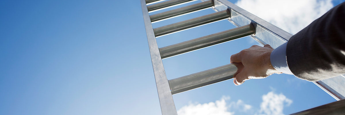 Businessman climbing the corporate ladder of success Schlagwort(e): corporate ladder, rung