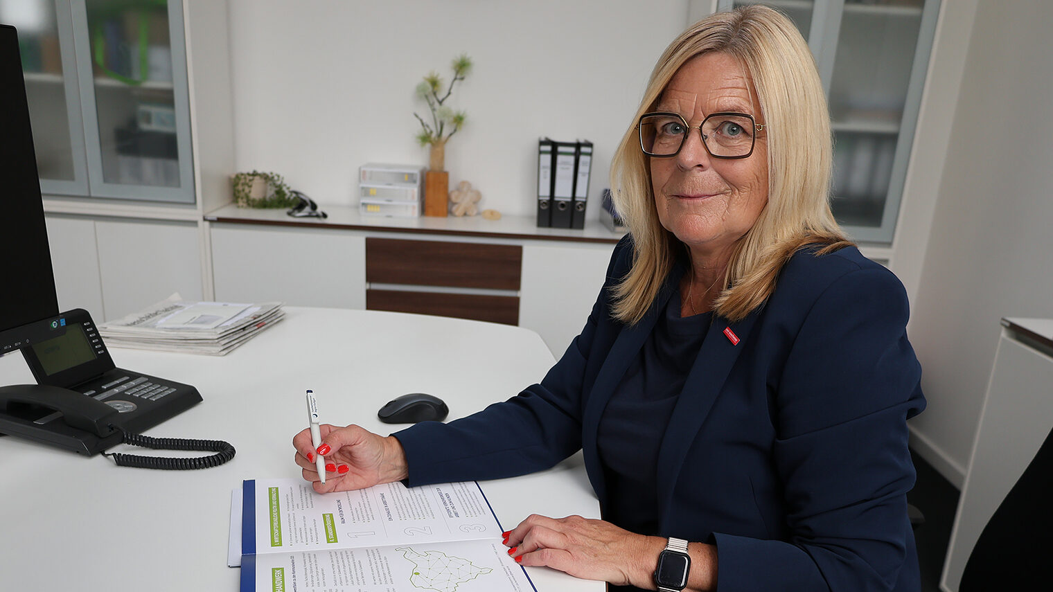 Uta Neumeister von der Handwerkskammer mit einem Heft mit den Kommunalwahlforderungen des Handwerks in Südwestfalen.