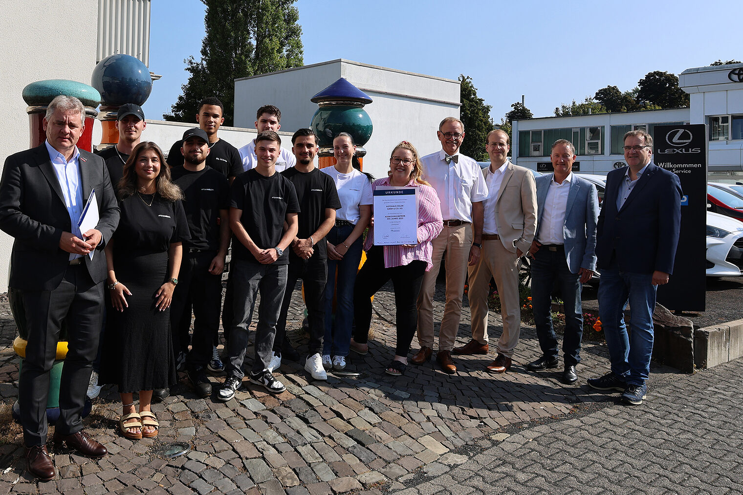 Gruppenfoto mit Geschäftsführung und Auszubildenden des Autohauses Keller sowie Vertretern der Handwerkskammer Südwestfalen.