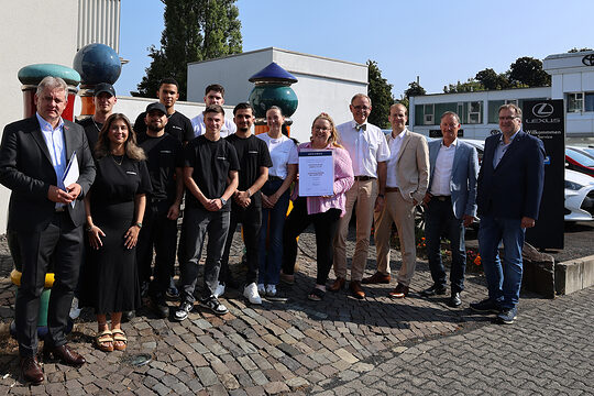 Gruppenfoto mit Geschäftsführung und Auszubildenden des Autohauses Keller sowie Vertretern der Handwerkskammer Südwestfalen.