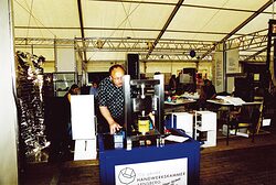 Eine Ausstellung von Produkten, Geräten und Maschinen aus dem Handwerk. Besucher schauen sich die Ausstellungsstücke an.