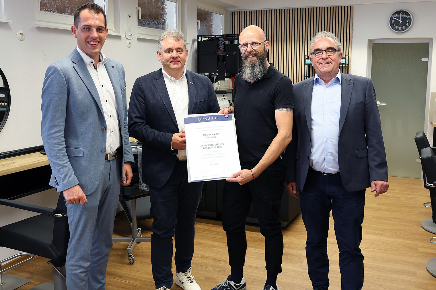 Gruppenfoto mit Friseurmeister Oliver Schmidt sowie Vertretern der Handwerkskammer, Kreishandwerkerschaft und Sparkasse. 