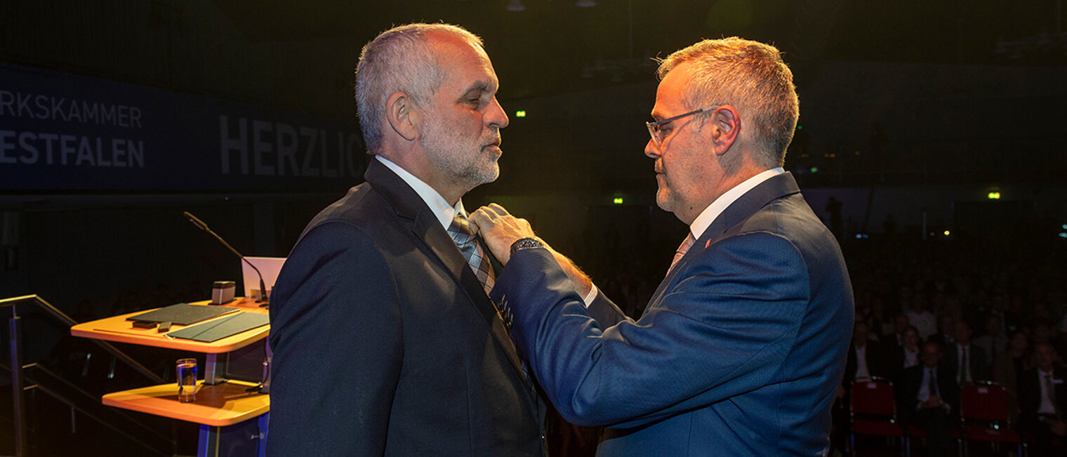 Jörg Dittrich steckt Jochen Renfordt die goldene Ehrennadel des Zentralverbands des Deutschen Handwerks an.