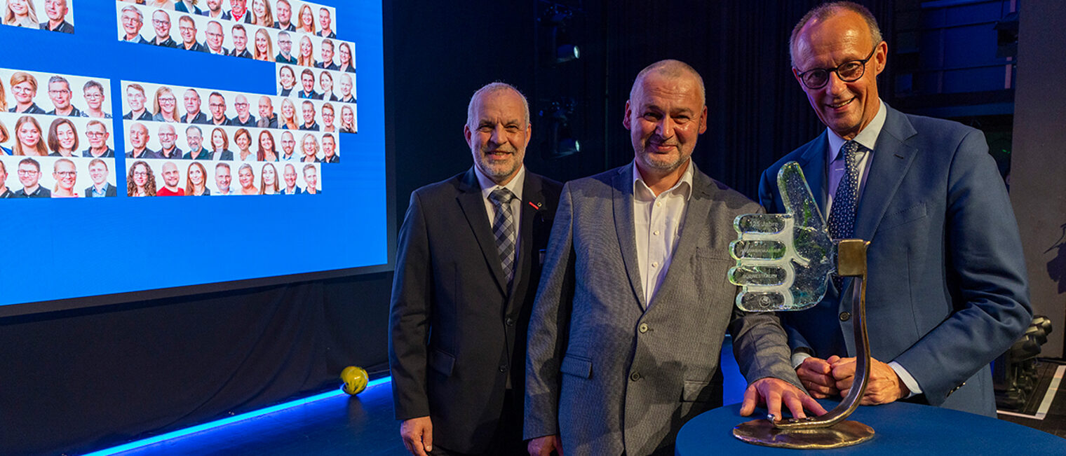 Übergabe einer Glasskulptur an Bundeskanzler Friedrich Merz bei der Veranstaltung "125 Jahre Handwerkskammer Südwestfalen".