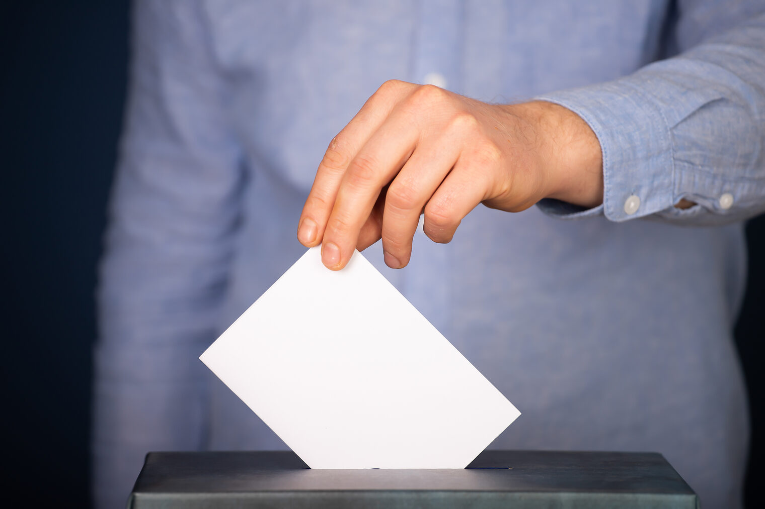 Ein Wähler wirft einen Stimmzettel in eine Wahlurne.