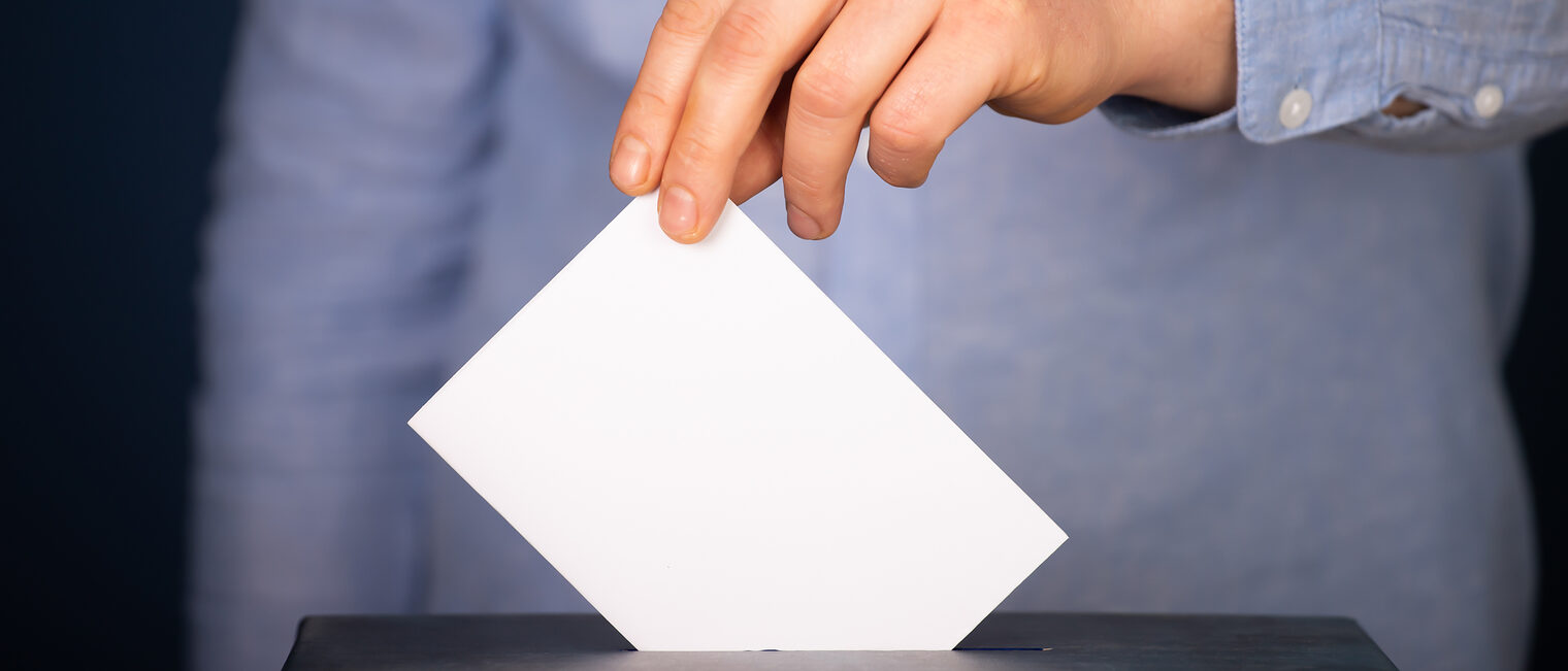 Ein Wähler wirft einen Stimmzettel in eine Wahlurne.