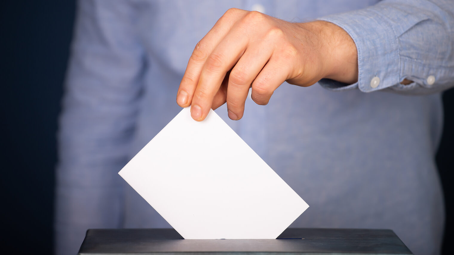 Ein Wähler wirft einen Stimmzettel in eine Wahlurne.