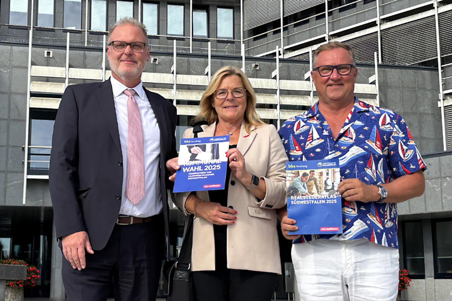 Gruppenfoto mit Handwerkskammer und Vertretern der Kreisverwaltung Märkischer Kreis. Im Hintergrund das Kreishaus Lüdenscheid