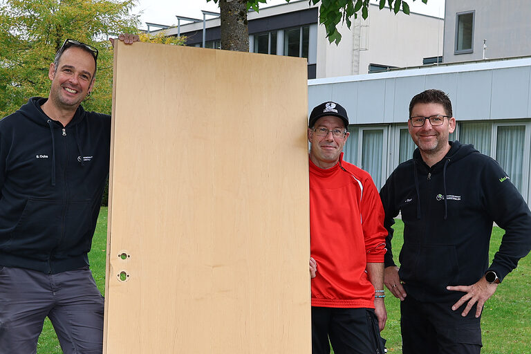 Gregor Hesse vom Josefsheim Bigge und zwei Hausmeister der Handwerkskammer Südwestfalen halten eine ausgebaute Tür.