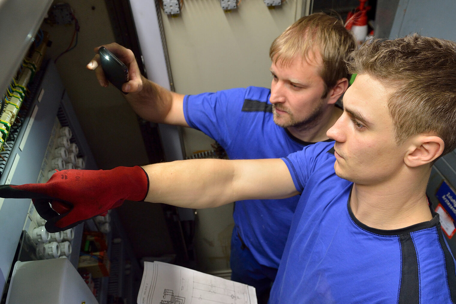 Ein Auszubildender für den Beruf Mechatroniker für Kältetechnik zusammen mit seinem Ausbilder bei der Arbeit.