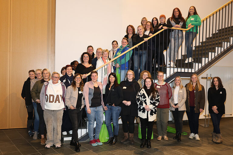 Gruppenbild der Teilnehmerinnen auf einer Treppe verteilt, sodass alle zu sehen sind.