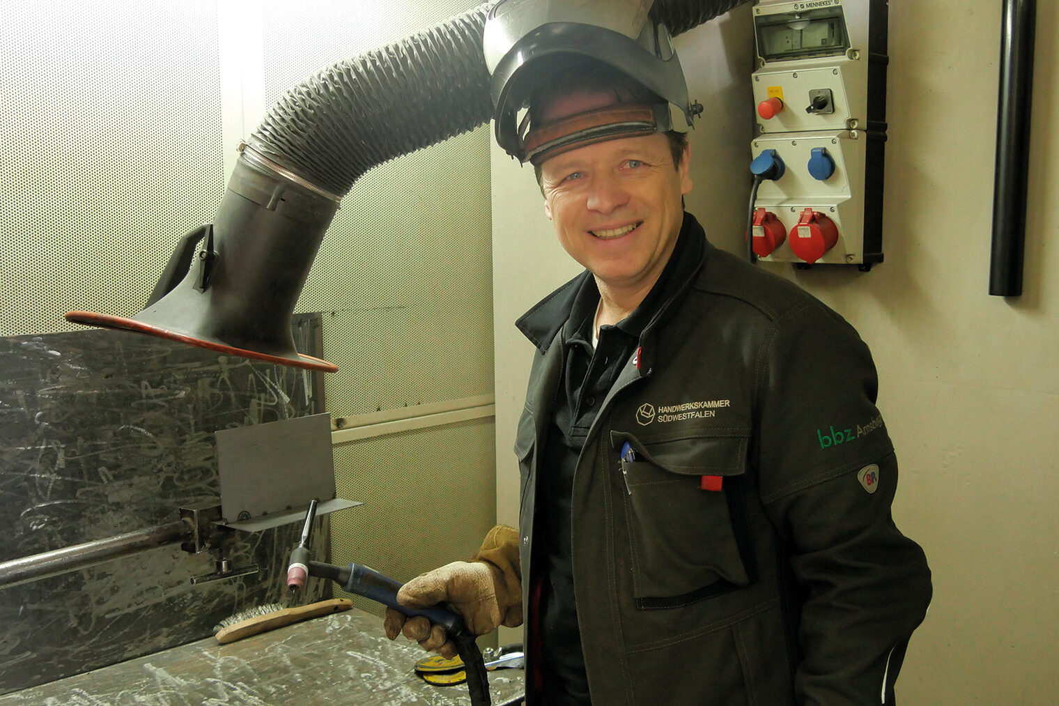 DVS-Schweißlehrer in Arbeitskleidung in einer Werkstatt im Berufsbildungszentrum Arnsberg.