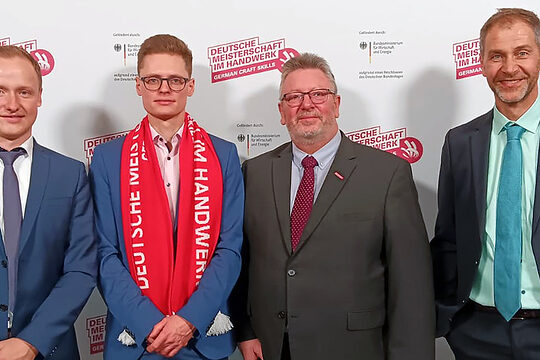DMH-Bundessieger David Giersbach gemeinsam mit HwK-Vizepräsident Michael Neuhaus sowie Christian Vogel und Philip Höhmann