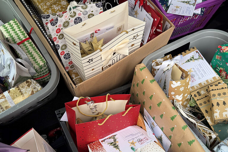 Etliche verpackte Geschenke liegen transportbereit in Kisten.