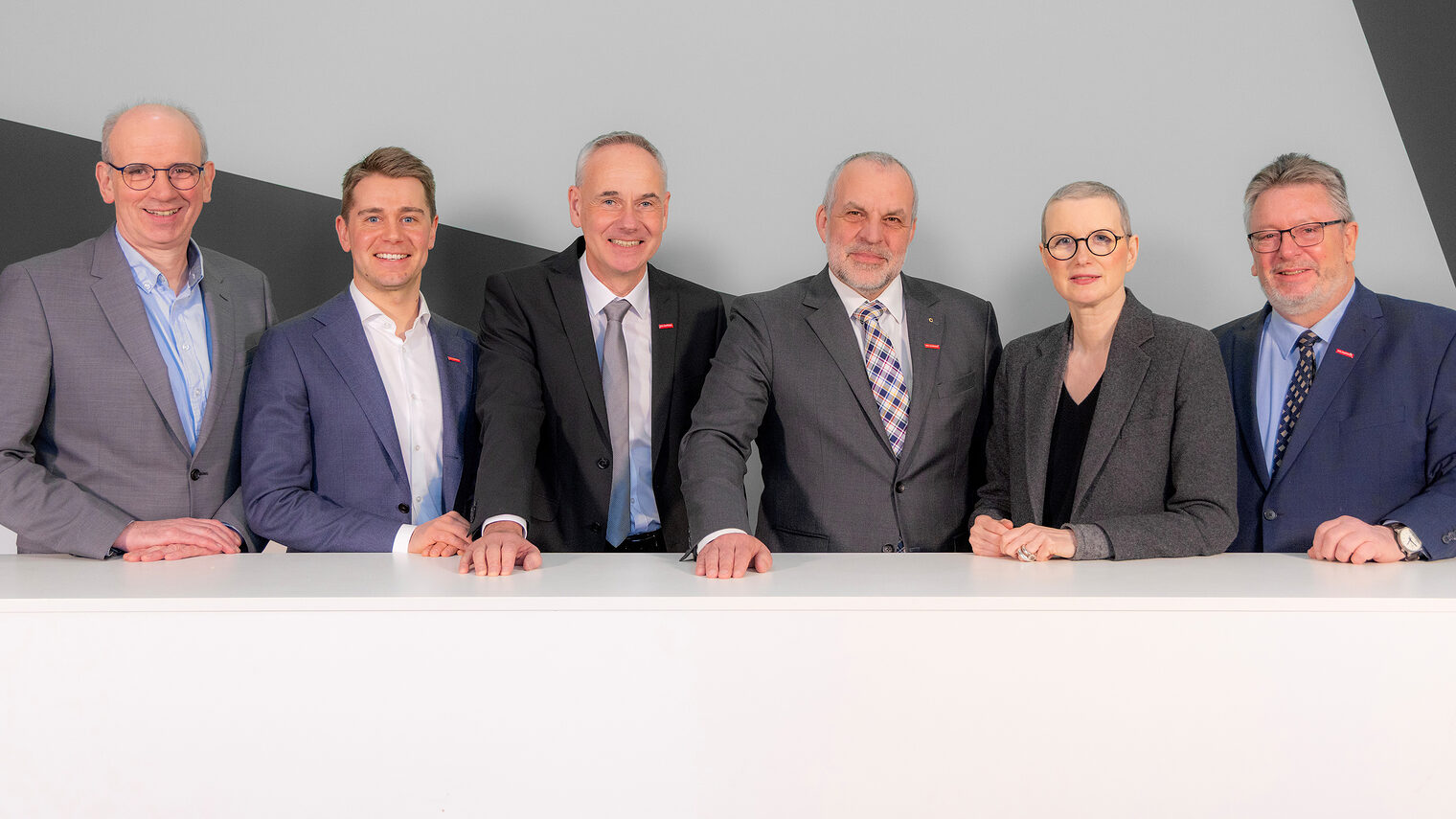 Gruppenbild des Vorstandes der Handwerkskammer Südwestfalen. Die Vorstandsmitglieder stehen hinter einem weißen Tisch.