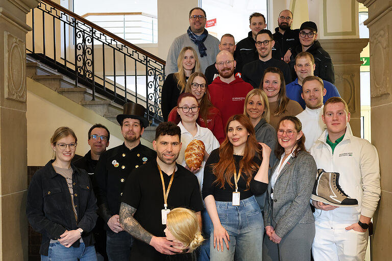 Vertreter von Handwerksbetrieben haben sich für ein Gruppenfoto auf einer historischen Treppe im Kreishaus Olpe aufgestellt.