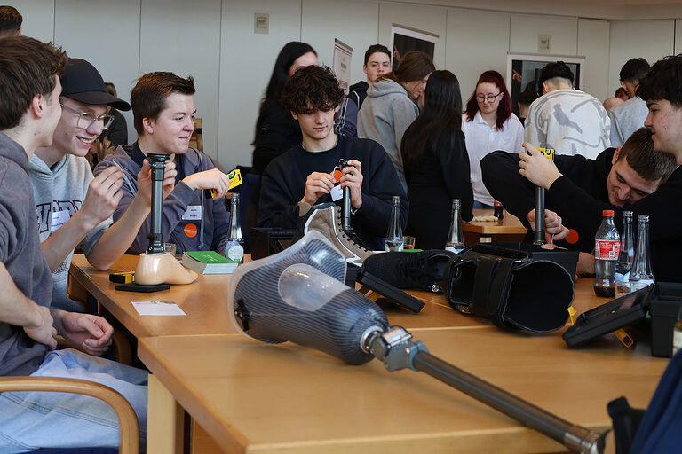 Praktische Übungen für Schülerinnen und Schülern an einem Infostand eines Orthopädietechniker-Betriebs.