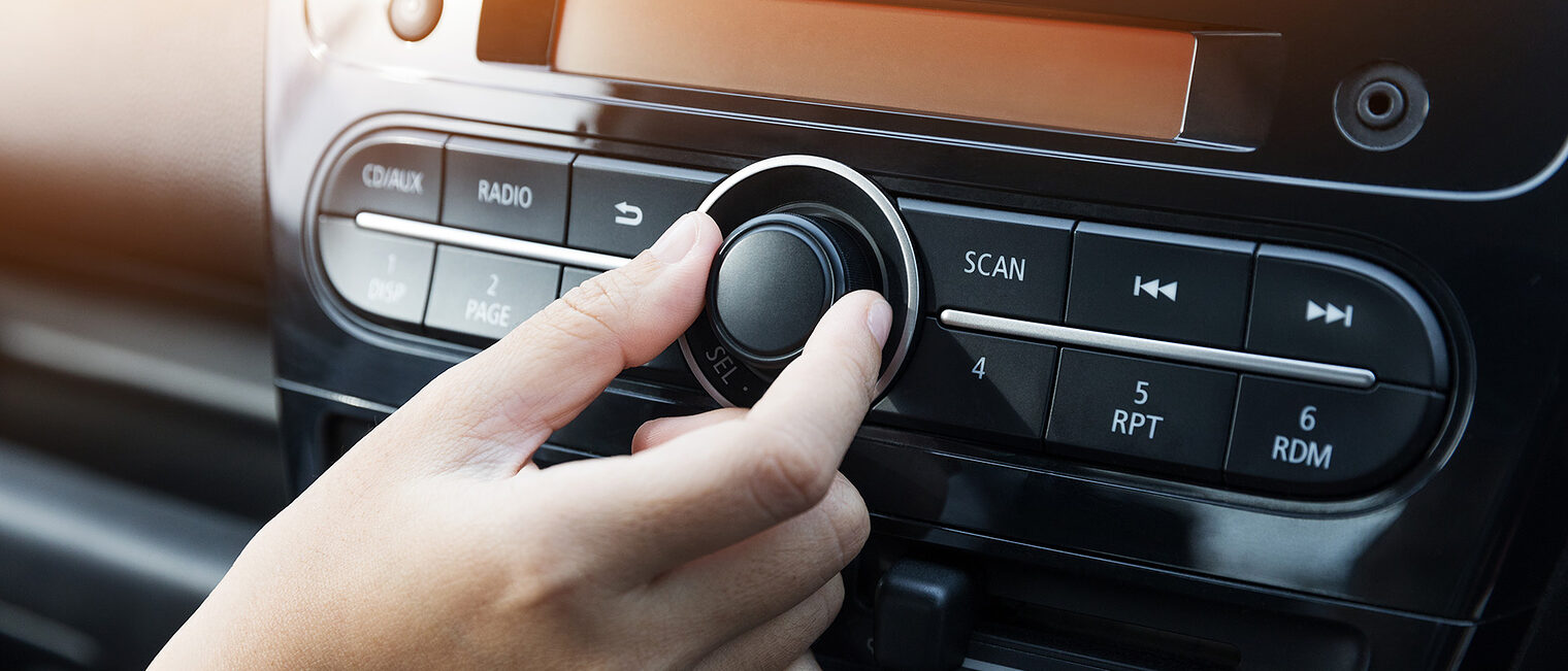 Eine Frau bedient ein Autoradio.