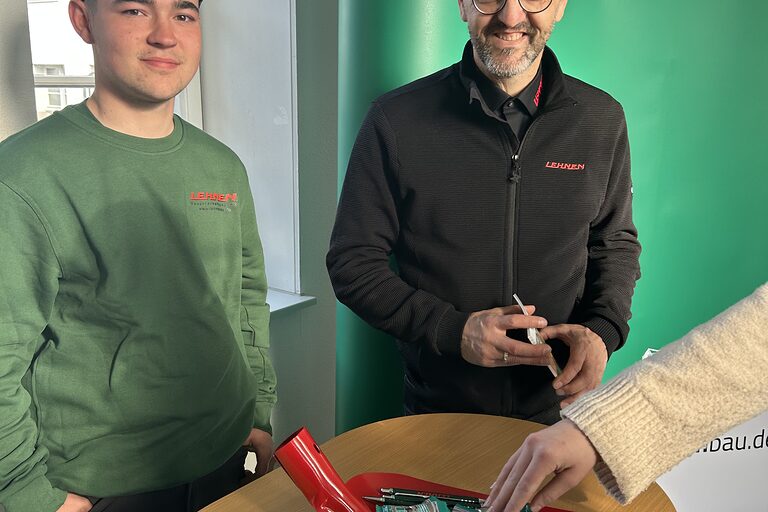 Zwei Mitarbeiter von Lehnen GmbH & Co. Bauunternehmung KG an einem Stand.