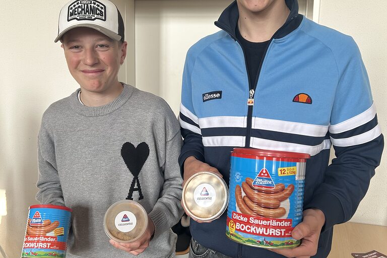 Zwei Schüler mit einem selbst hergestelltem Grillgewürz und einer Dose Bockwürste der Metten Fleischwaren GmbH & Co. KG.
