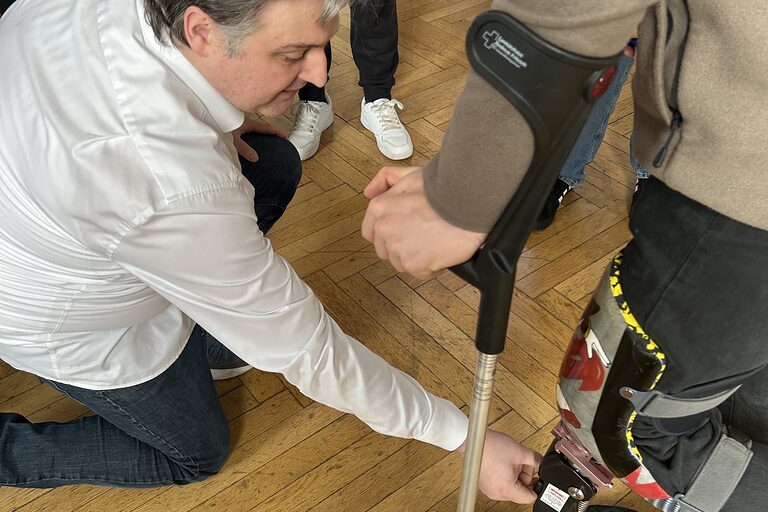 Ein Schüler, der sich eine Fußprothese angelegt hat. Ein Mitarbeiter des Sanitätshaus Andreas Fritzsch prüft die Prothese.