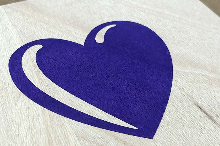 Ein lila Herz auf weißer Oberfläche.