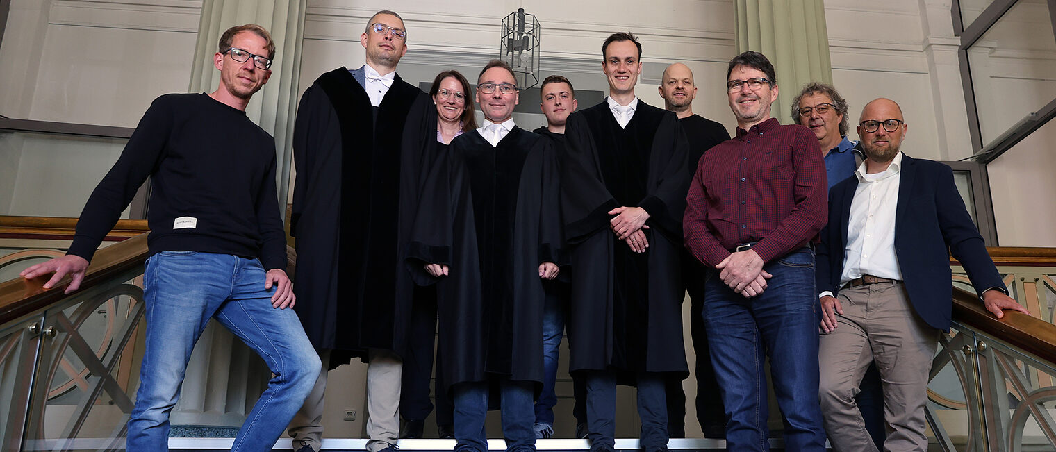 Eine Gruppe von Sachverständigen der Handwerkskammer auf einer Treppe im Landgericht Arnsberg.