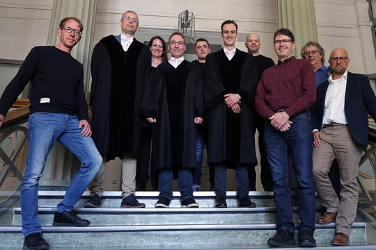 Eine Gruppe von Sachverständigen der Handwerkskammer auf einer Treppe im Landgericht Arnsberg.