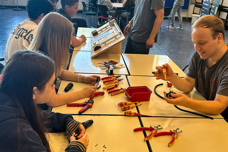 Schülerinnen und Schüler verdrahten eine Abzweigdose.