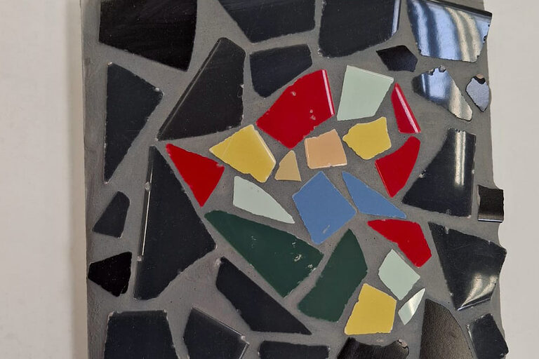 Ein buntes Mosaik-Herz in schwarzer Umrandung.
