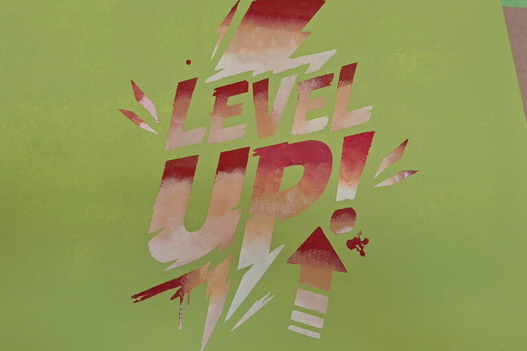 Der Schriftzug "Level Up" in Rottönen auf einer grünen Platte.