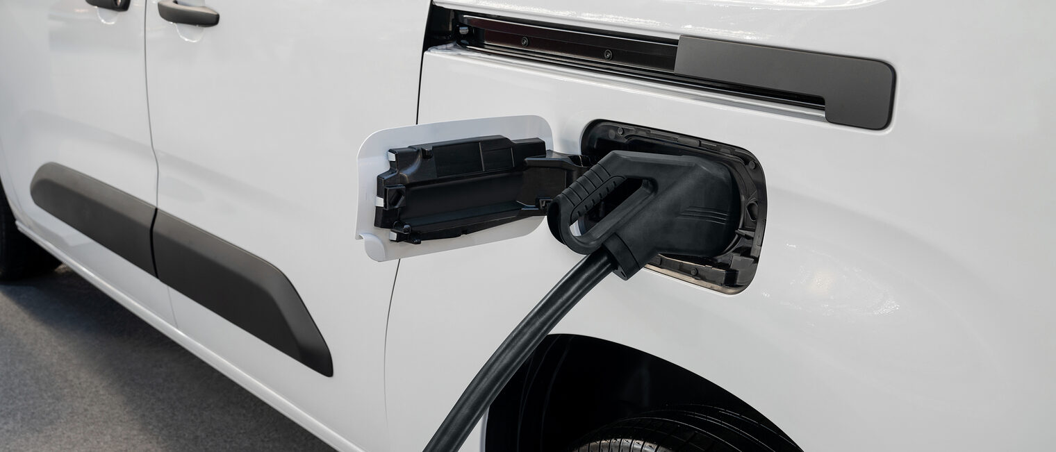 Ein Elektro-Lieferwagen wird an einer Ladestation geladen.