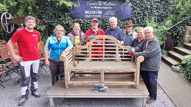 Gruppenfoto von Ehrenamtlichen, die Gartenmöbel im Museumsgarten Haus Hövener restauriert haben.