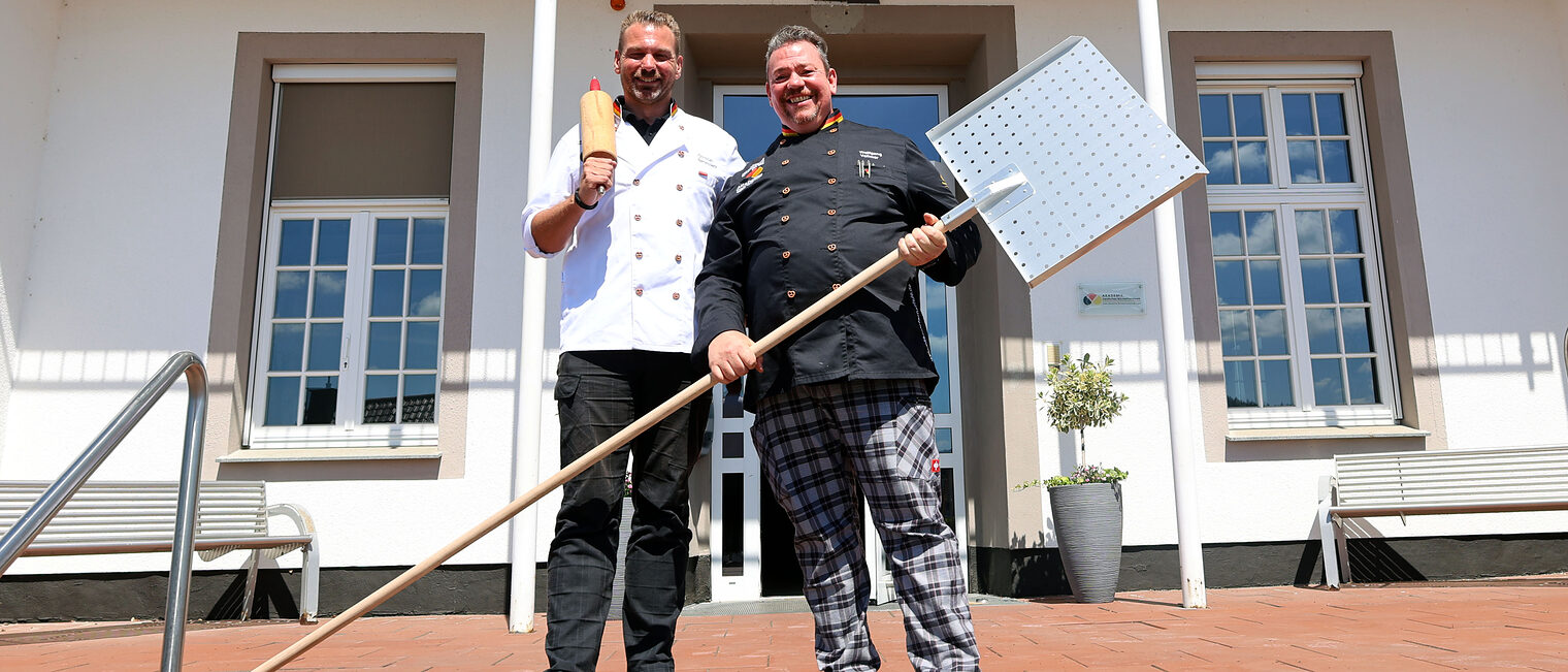 Die Schulleiter Christian Bertelsbeck und Wolfgang Vollmer vor dem Haupteingang der Bäckerfachschule in Olpe.