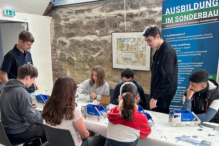Schülerinnen und Schüler schrauben am Stand von Dünschede Fahrzeugbau