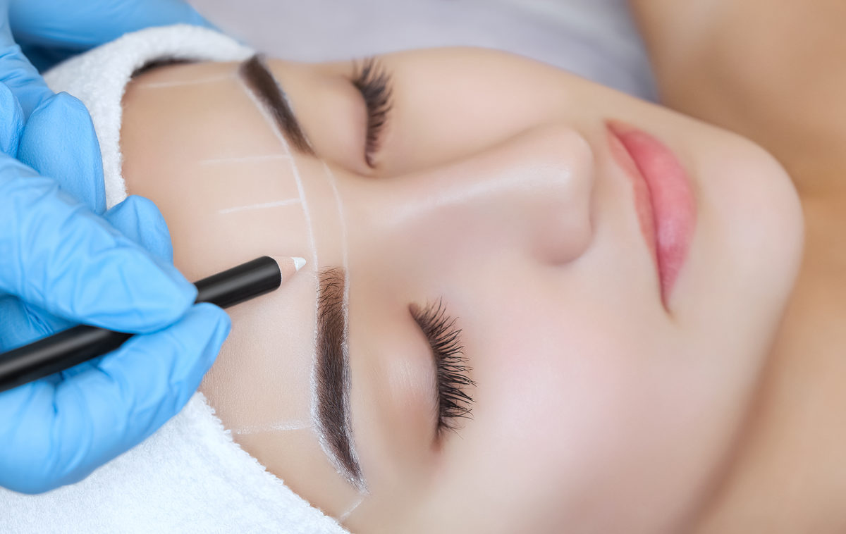 Permanent make-up for eyebrows of beautiful woman with thick brows in beauty salon. Closeup beautician doing tattooing eyebrow. Schlagwort(e): lash, microblading