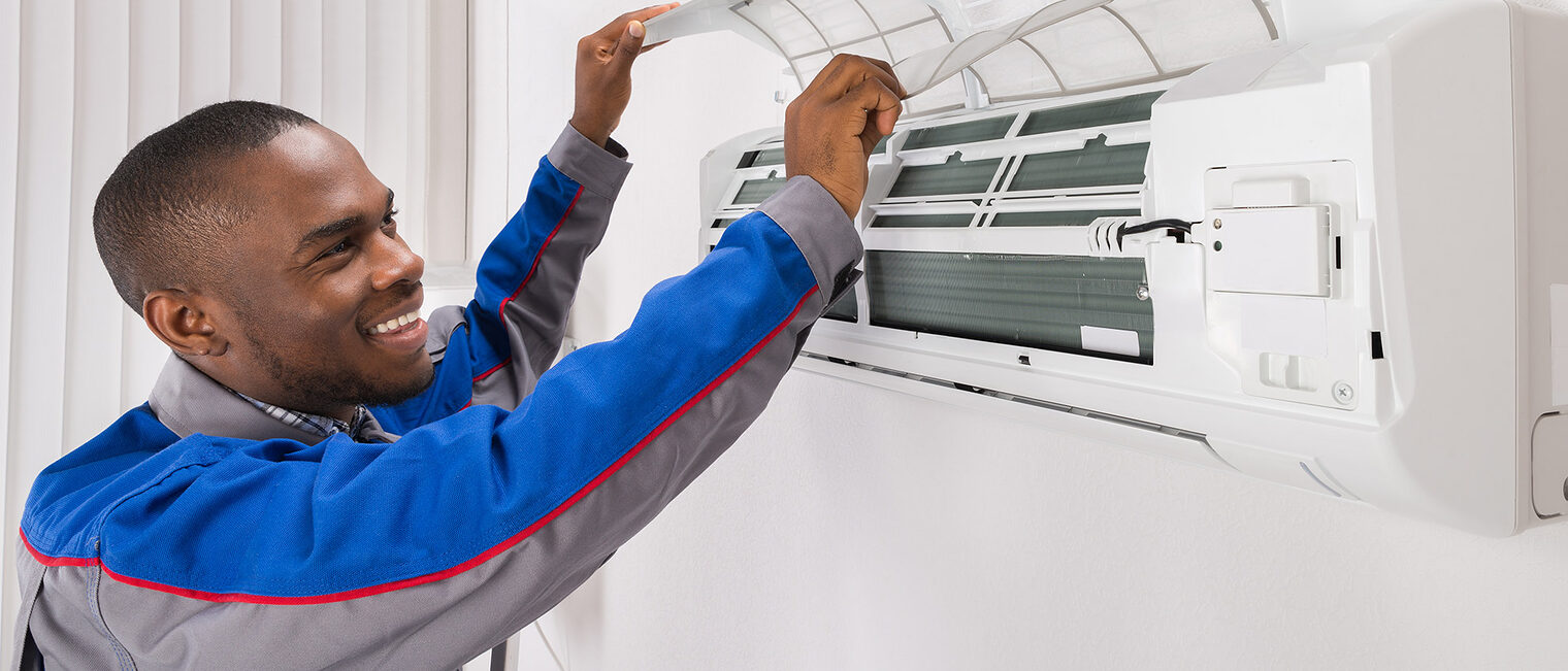 Happy Male Technician Checking Air Conditioner At Home